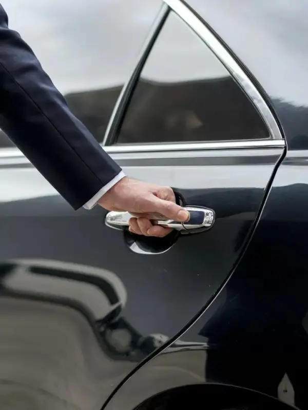 Chauffeur öffnet die Tür einer Luxuslimousine
