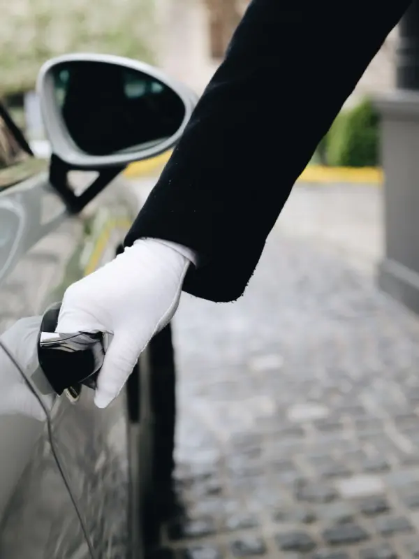 Chauffeur öffnet die Tür einer Luxuslimousine