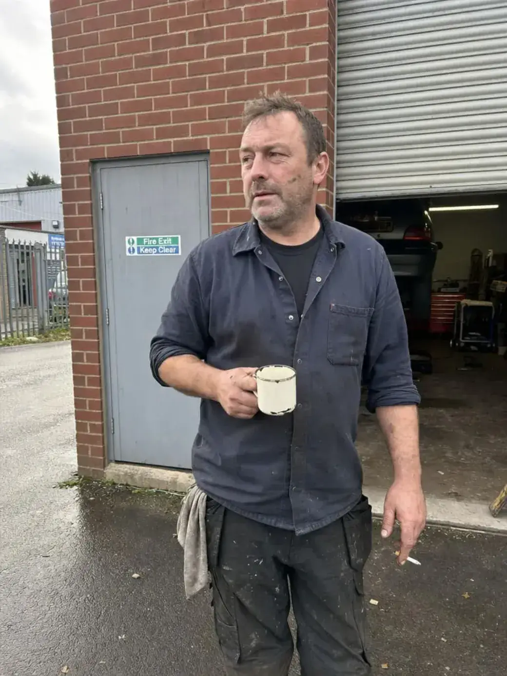 Body shop technician outside garage